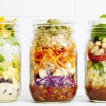 Mason jars packed with colorful layered salads