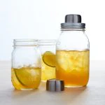 Mason jars used as drinking glasses and a cocktail shaker, filled with iced tea and lime